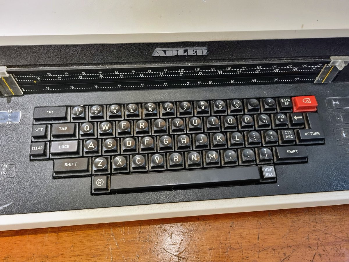 Close view of a typewriter keyboard, its keys in neat rows