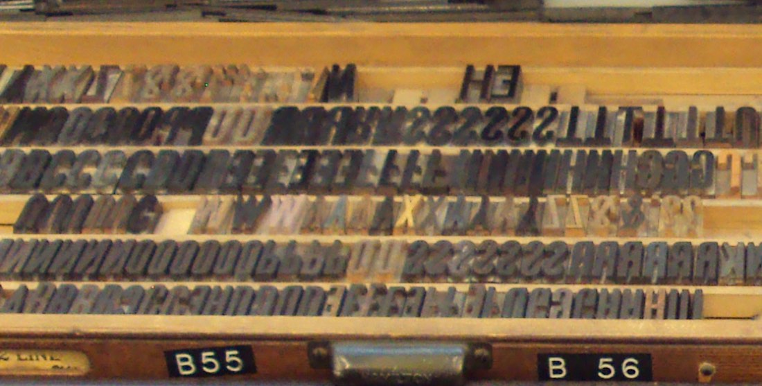 Metal letterpress type sorted into the compartments of a wooden case