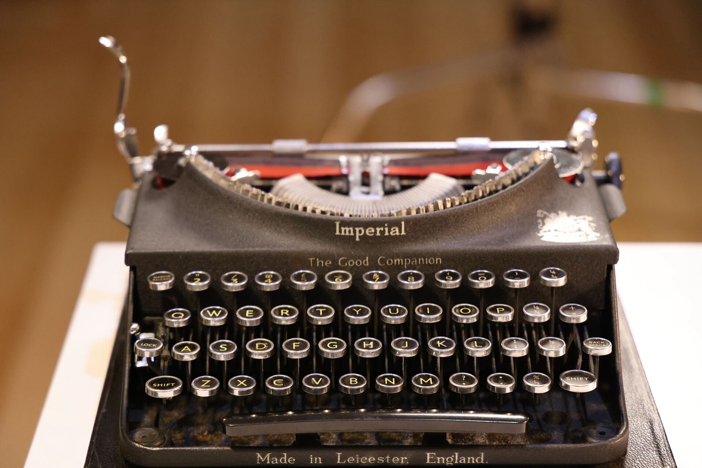 Close view of an Imperial typewriter, its keys and carriage rail in warm light